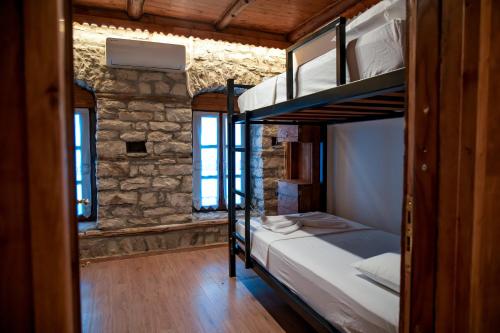 a bedroom with two bunk beds in a brick wall at Beds Hostel in Gjirokastër