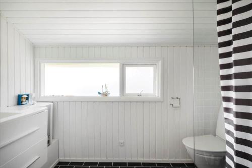 a white bathroom with a window and a toilet at JB507-Fjerritslev-Perikumvej-50 in Slettestrand