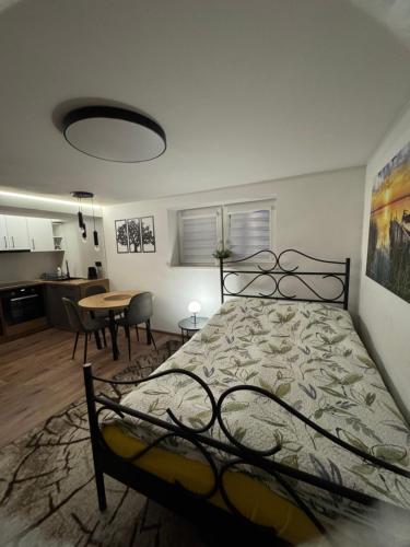 a bedroom with a bed and a table and a kitchen at Apartament M1 w centrum Wiela in Wiele