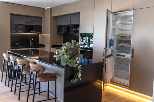 a kitchen with a black counter and bar stools at At Home Alonso in Santiago