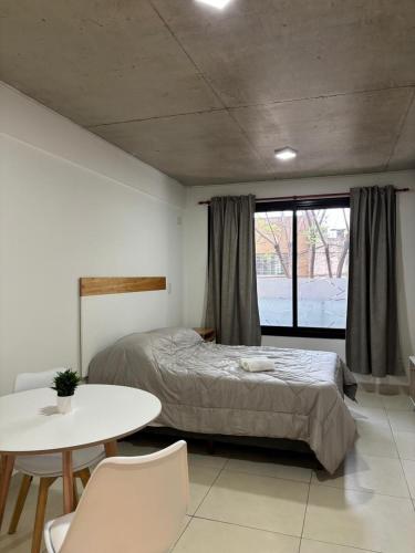 a bedroom with a bed and a table with chairs at Bnb loft XlV - Pasos Bv oroño y Av pellegrini in Rosario