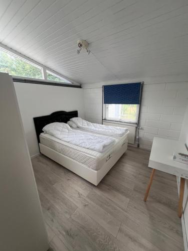 a bedroom with a bed in a room with a table at Sommerhus in Grevinge