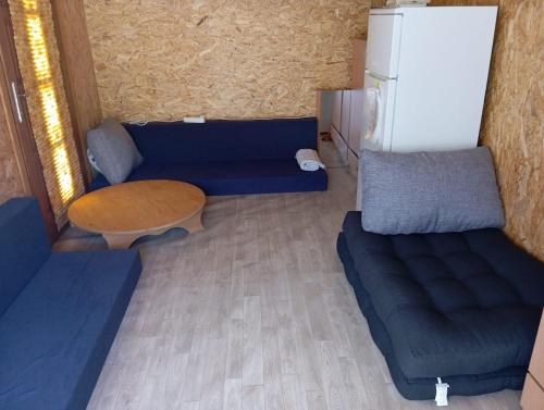 a living room with a couch and a table and a refrigerator at Pliva Escape in Jezero