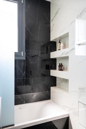 a bathroom with a black and white shower at Thalori villa 2 in Psalidi