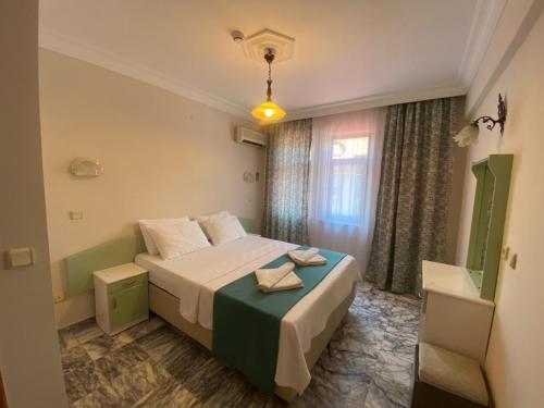 a hotel room with a bed and a window at ÖZ-AY APART OTEL in Marmaris