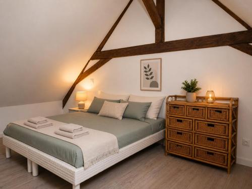 a bedroom with a large bed and a dresser at Maison Charton in Château-Chinon