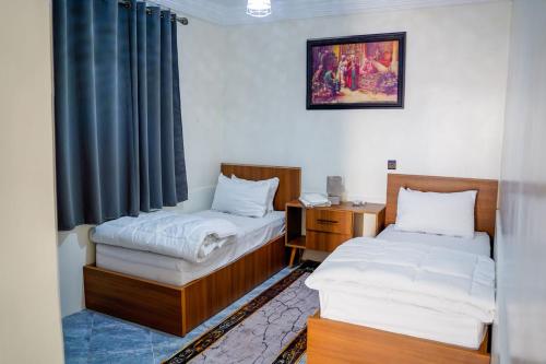 a room with two beds and a desk and a window at oasis house in Takchrirt