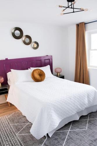 a bedroom with a white bed with a purple headboard at 4 Guest Suite with Waterfront Views at Fancie's PEC - Suite 2 in Belleville