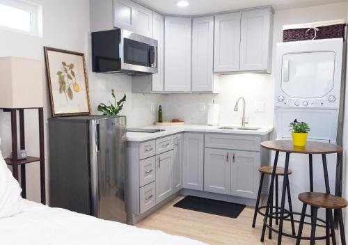 a kitchen with white cabinets and a stainless steel refrigerator at Yellow Gate Executive Retreat in San Jose
