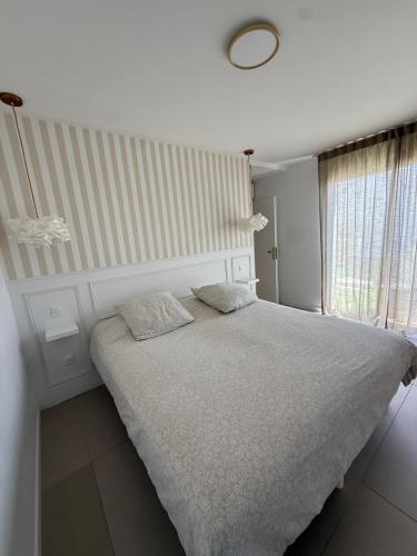 a bed with two pillows on it in a bedroom at Maison des Oliviers in Puilboreau