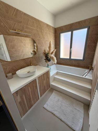 a bathroom with stairs and a sink and a window at Maison des Oliviers in Puilboreau