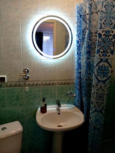 a bathroom with a sink and a mirror and a toilet at Pokoje gościnne u Aleksandry in Hel