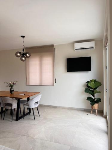 a dining room with a table and a tv at Zen Apartment in Santa Maria del Cedro