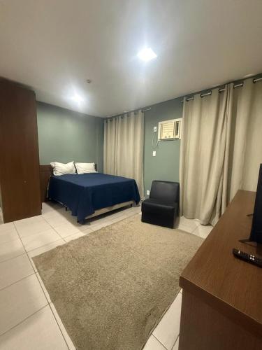 a bedroom with a blue bed and a chair at Residencial DOM in Lorena