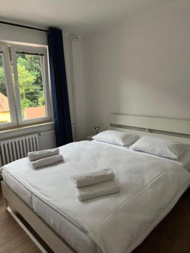 a bedroom with a large white bed with towels on it at Wellness apartment Karlštejn in Karlštejn
