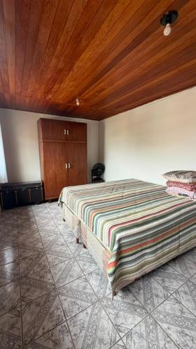 a bedroom with a bed and a wooden ceiling at downtown Teófilo Otoni in Teófilo Otoni