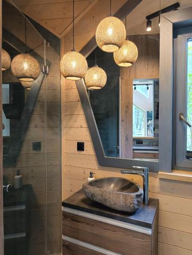 a bathroom with a sink and a mirror and lights at Domy Kopułowe 5th Wymiar in Skrybicze