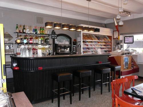 een bar met zwarte krukken in een restaurant bij La Casa Mia in Sainte-Maxime