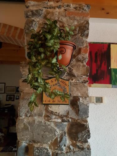 a clock on a stone wall with a potted plant at B&B La Cà De La Frà in Gravedona