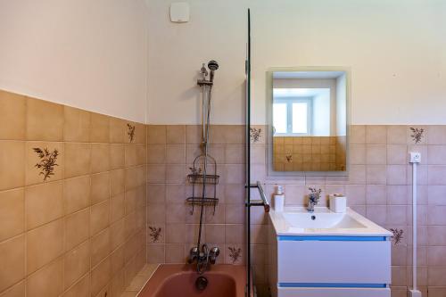 a bathroom with a shower with a sink and a red tub at Ti Coet Salio - Nature & calme près de Guerlédan in Guerlédan