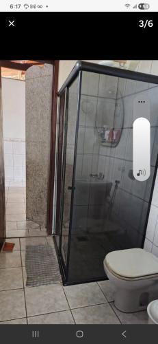 a bathroom with a shower with a toilet and a sink at downtown Teófilo Otoni in Teófilo Otoni