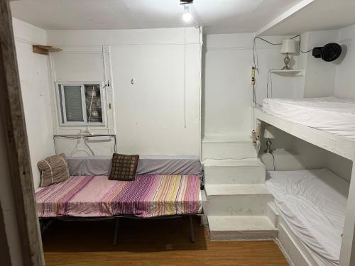 a small room with two bunk beds and a bench at the Brooklyn Riviera in Brooklyn