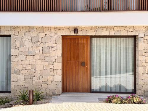 a wooden door on the side of a stone building at Grota Lodging in Leiria