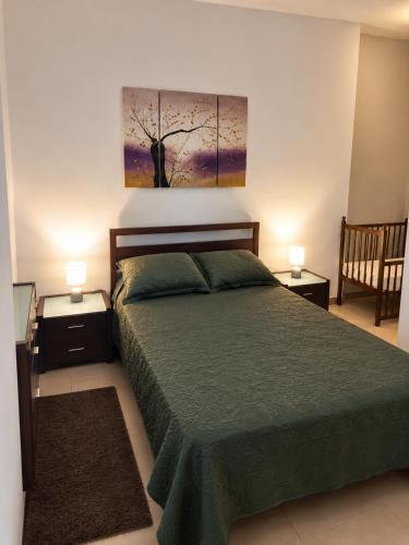 a bedroom with a green bed and two night stands at Sliema central apartment in Sliema