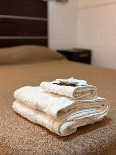 a pile of towels sitting on top of a bed at Hotel y Cabañas Gran Cordoba in La Falda