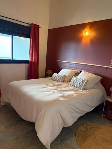 a large white bed in a room with a window at Kaz mer veille in Les Avirons