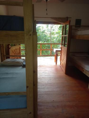 a bedroom with a bunk bed and a porch at Roatan Onat Hostel 1 in West End