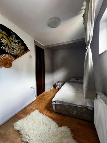 a bedroom with a bed and a white rug at Casa Dany in Zărneşti