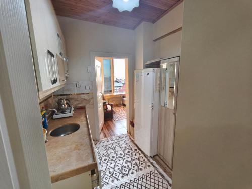 a kitchen with a sink and a refrigerator at Sağlık Apart Pansiyon in Erdek