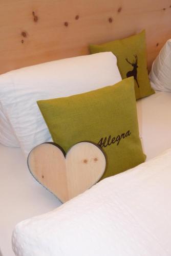 a bed with a pillow with a heart on it at Wellnesshotel Liun in Müstair
