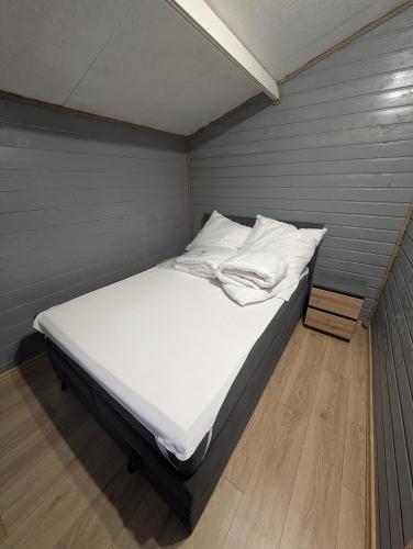 a bed with white sheets and pillows in a room at Apartamenty na Widoku Chłopy in Chłopy