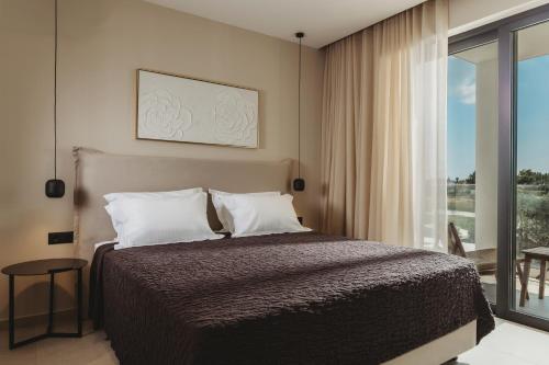 a bedroom with a bed and a large window at Serenita luxury villa in Zakynthos