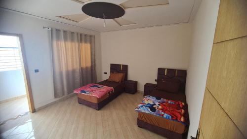 a room with two beds and a ceiling at Appartement propre in Saïdia