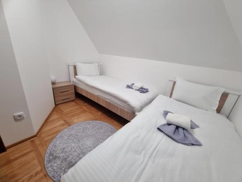 a room with two beds and a table at Kuća za odmor Lavanda in Sirogojno