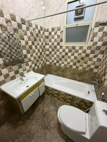 un bagno con lavandino, WC e vasca di Naforah a Al Ain