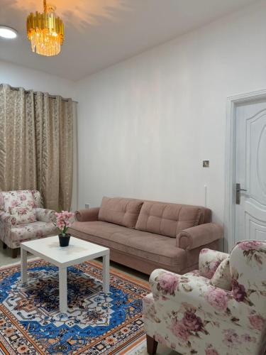 ein Wohnzimmer mit einer Couch, zwei Sesseln und einem Tisch in der Unterkunft Naforah in al-Ain