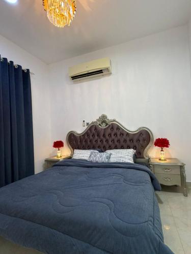 ein Schlafzimmer mit einem großen Bett und einer blauen Decke in der Unterkunft Naforah in al-Ain