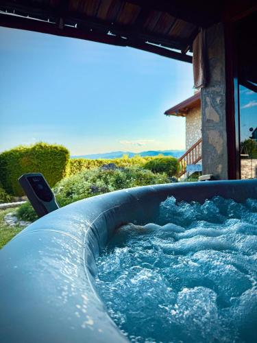 a hot tub filled with water in a yard at Cozy Green Escape in Kakanj