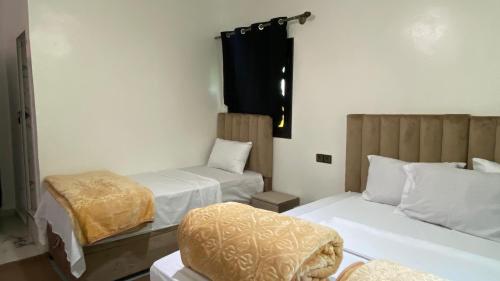 a hotel room with two beds and a window at Beldi apparemment in Imlil