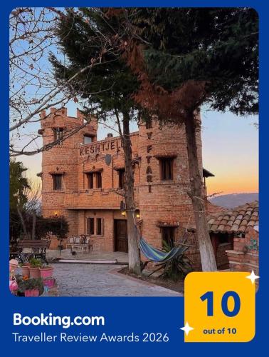 a brick building with a tree in front of it at Kështjella Myftari in Patos