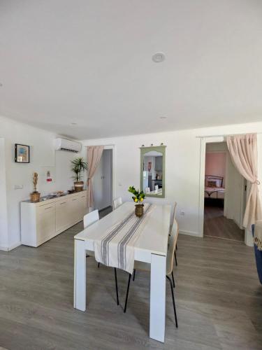 a white dining room with a white table and chairs at Alojamento Lazer in Folgosa