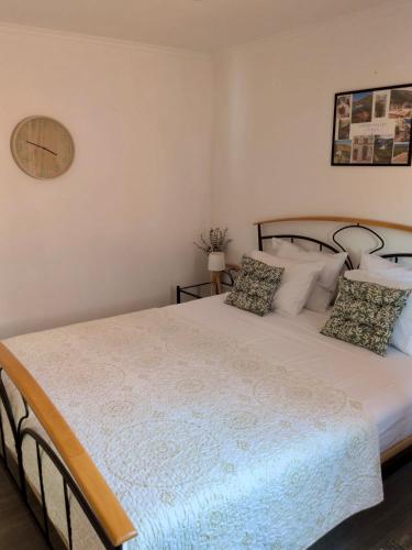 a bedroom with a large white bed with pillows at Alojamento Lazer in Folgosa