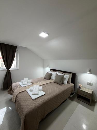 a bedroom with a large bed with two trays on it at NINAS Apartments in Elshani