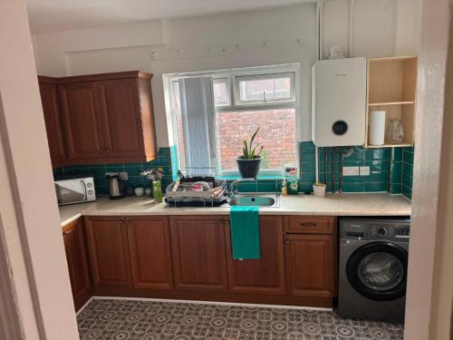 a kitchen with wooden cabinets and a sink and a window at Crosby & Waterloo Beachside Stay in Waterloo