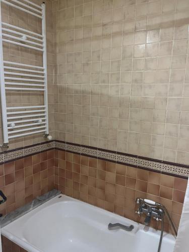 a bathroom with a bath tub and a sink at Arabesque-style apartment in Yasmine