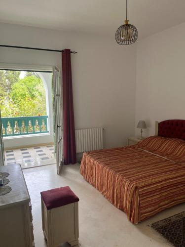 a bedroom with a bed and a large window at Arabesque-style apartment in Yasmine